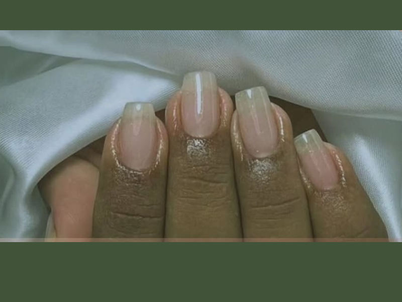 Procedimento de banho de gel sendo aplicado nas unhas